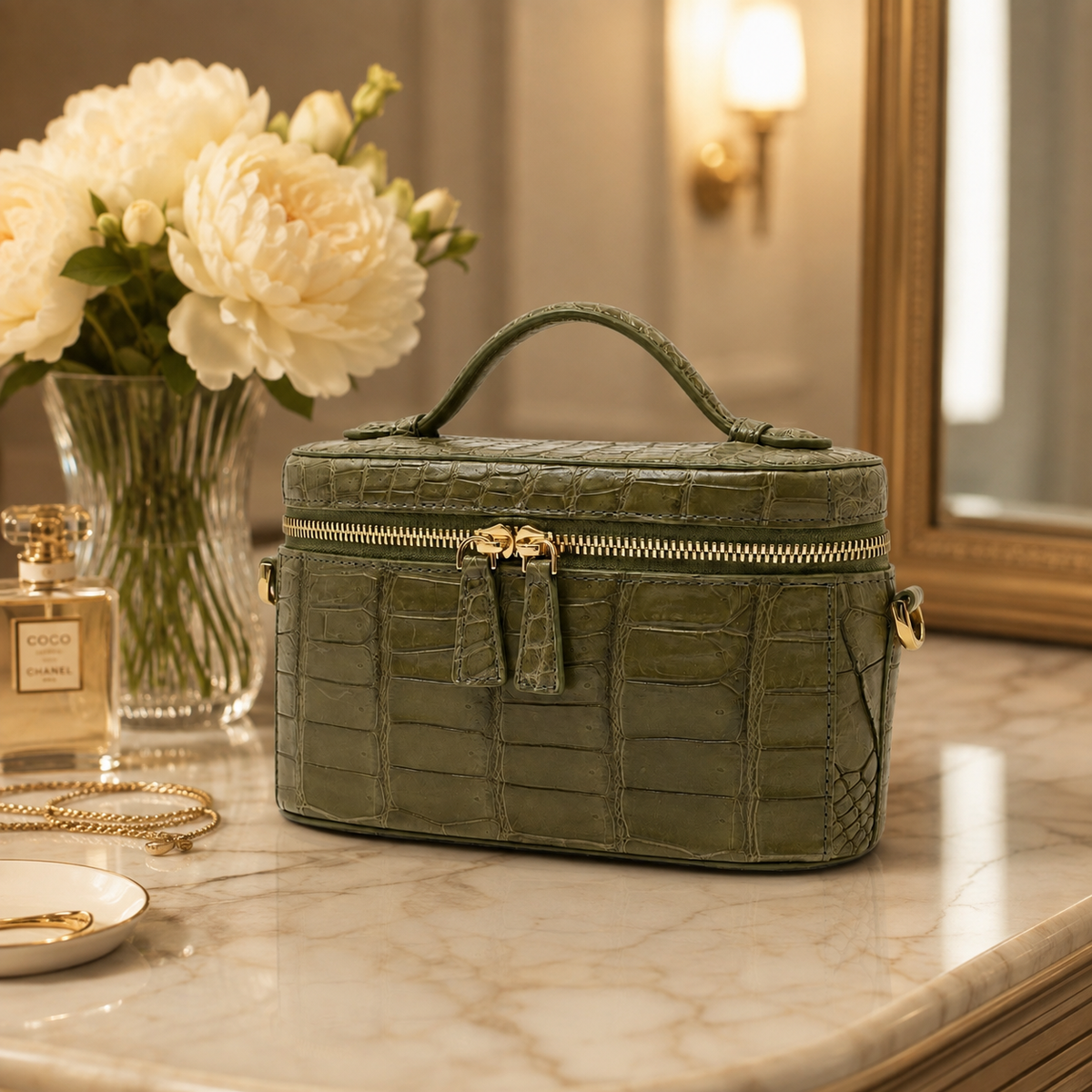 Sage Olive Clarendon genuine Siamese crocodile mini box bag styled on a luxury vanity with gold-tone hardware, top handle, and structured travel case silhouette.