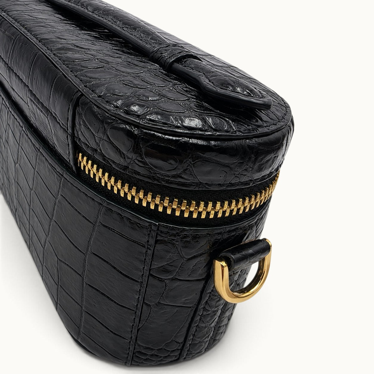 Luxury craftsmanship close-up of Classic Black genuine crocodile leather with natural scales, stitching and gold-tone YKK hardware.