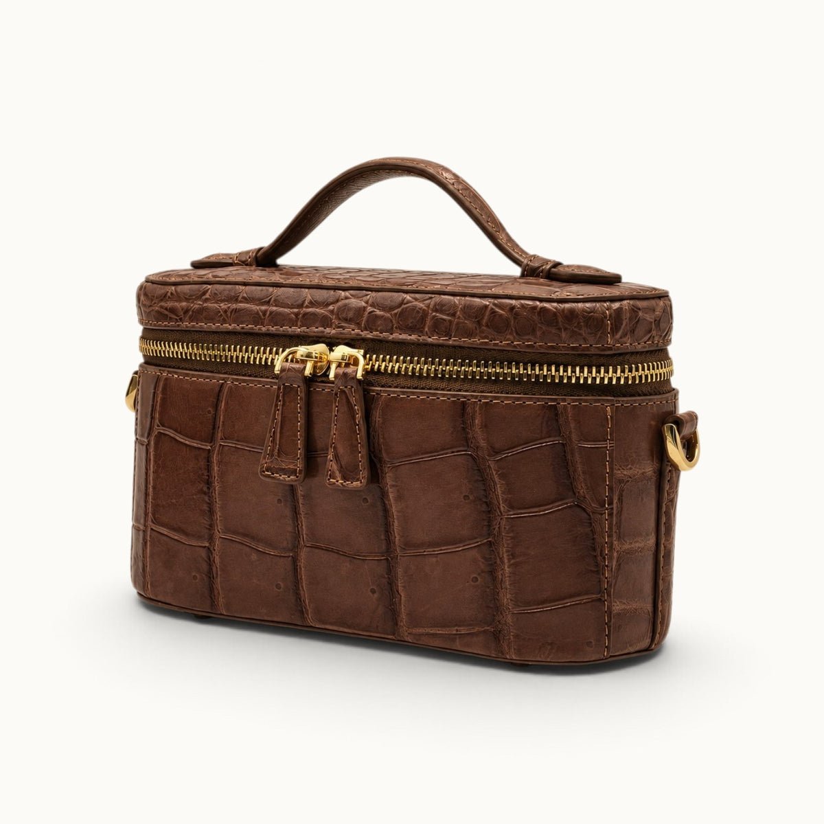 Angle view of a Cocoa Brown genuine Siamese crocodile box bag with structured top handle and luxury vanity-inspired shape.