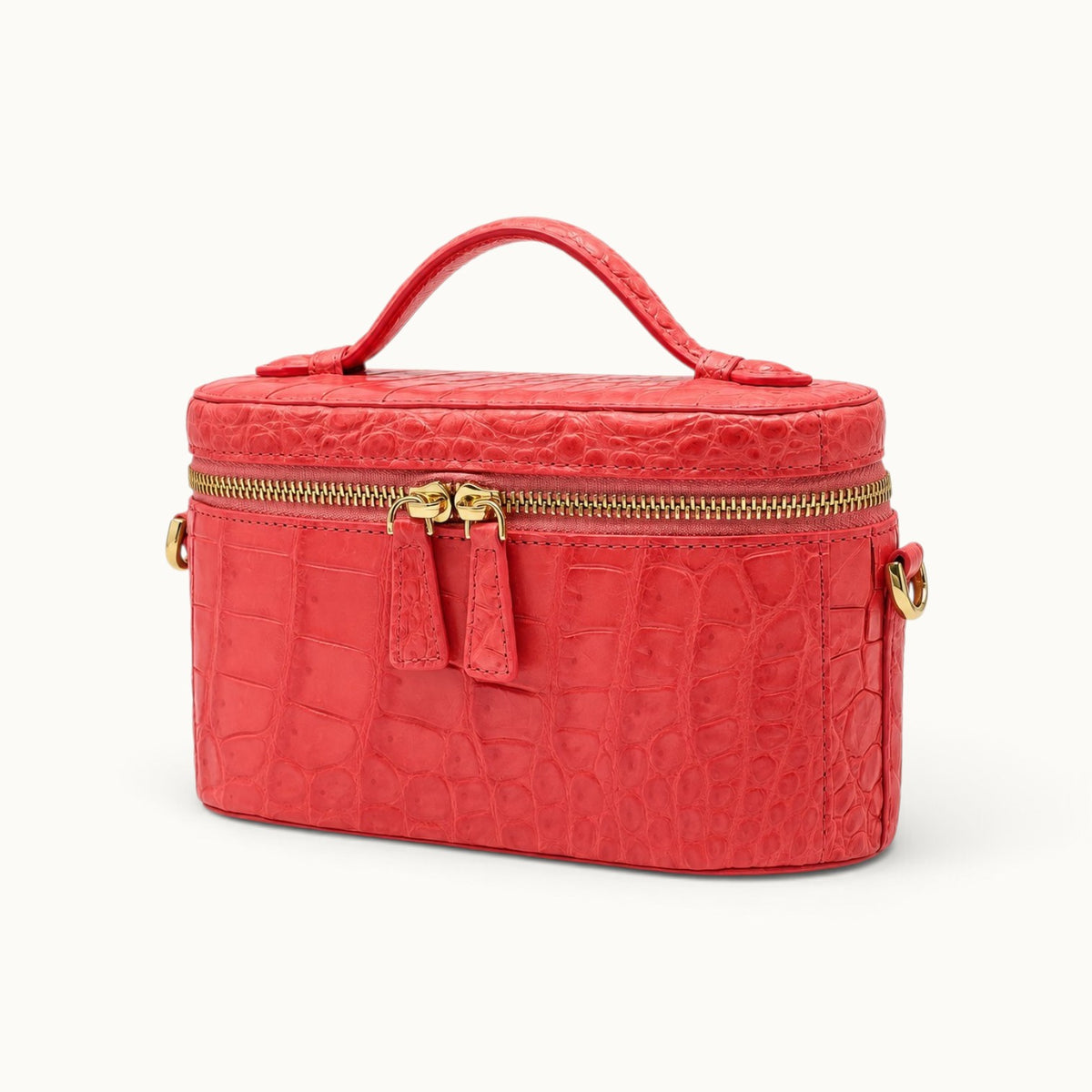 Angle view of a Coral Red luxury crocodile mini handbag with structured box shape, double zipper and top handle.