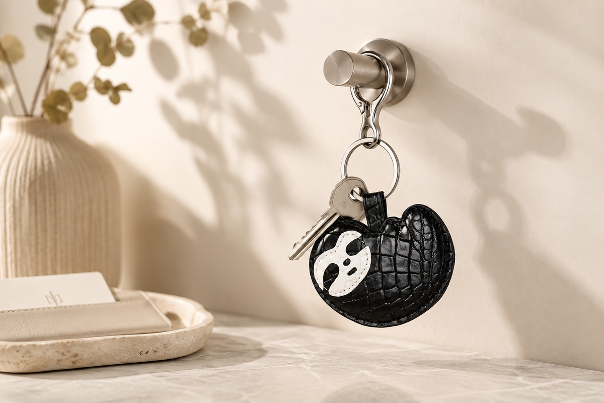 Jet Black Crocodile Palette Bag Charm with keys hanging from a wall hook in a refined entryway