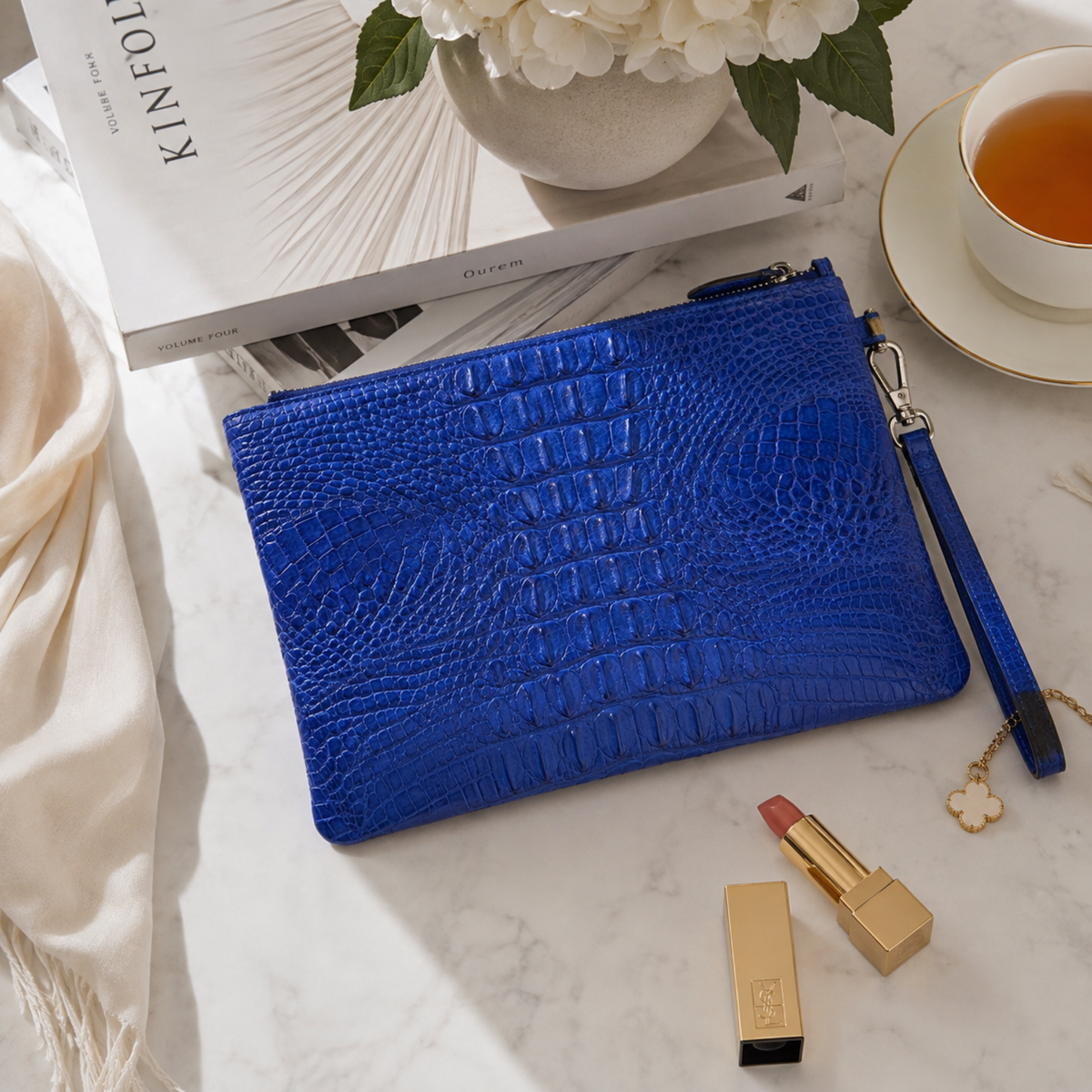 Royal blue designer crocodile clutch bag styled as a sophisticated luxury accessory