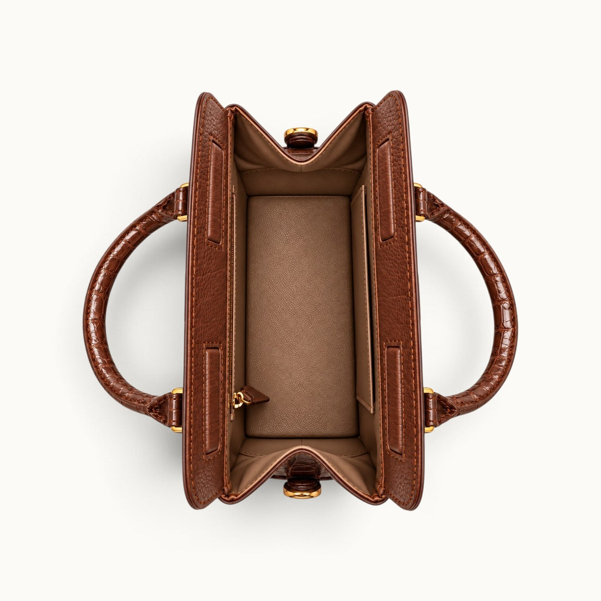Overhead view of The Ellery Crocodile Handbag in Cocoa Brown, showing its open main compartment, full-grain cow leather lining, and interior pockets.