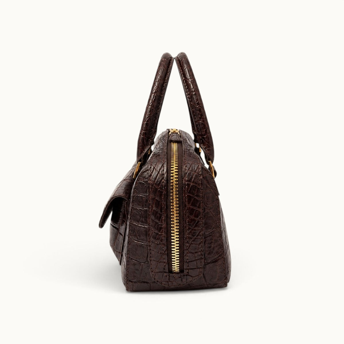 Espresso brown crocodile handbag side view showing structured profile and gold-tone zipper