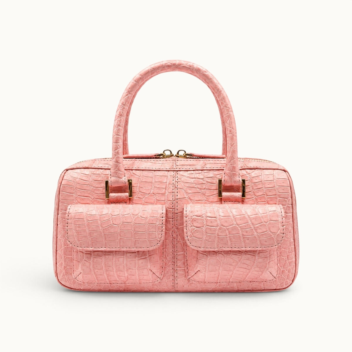 Front view of The Fairmont blush pink crocodile handbag with dual flap pockets, structured shape, and polished gold-tone hardware.