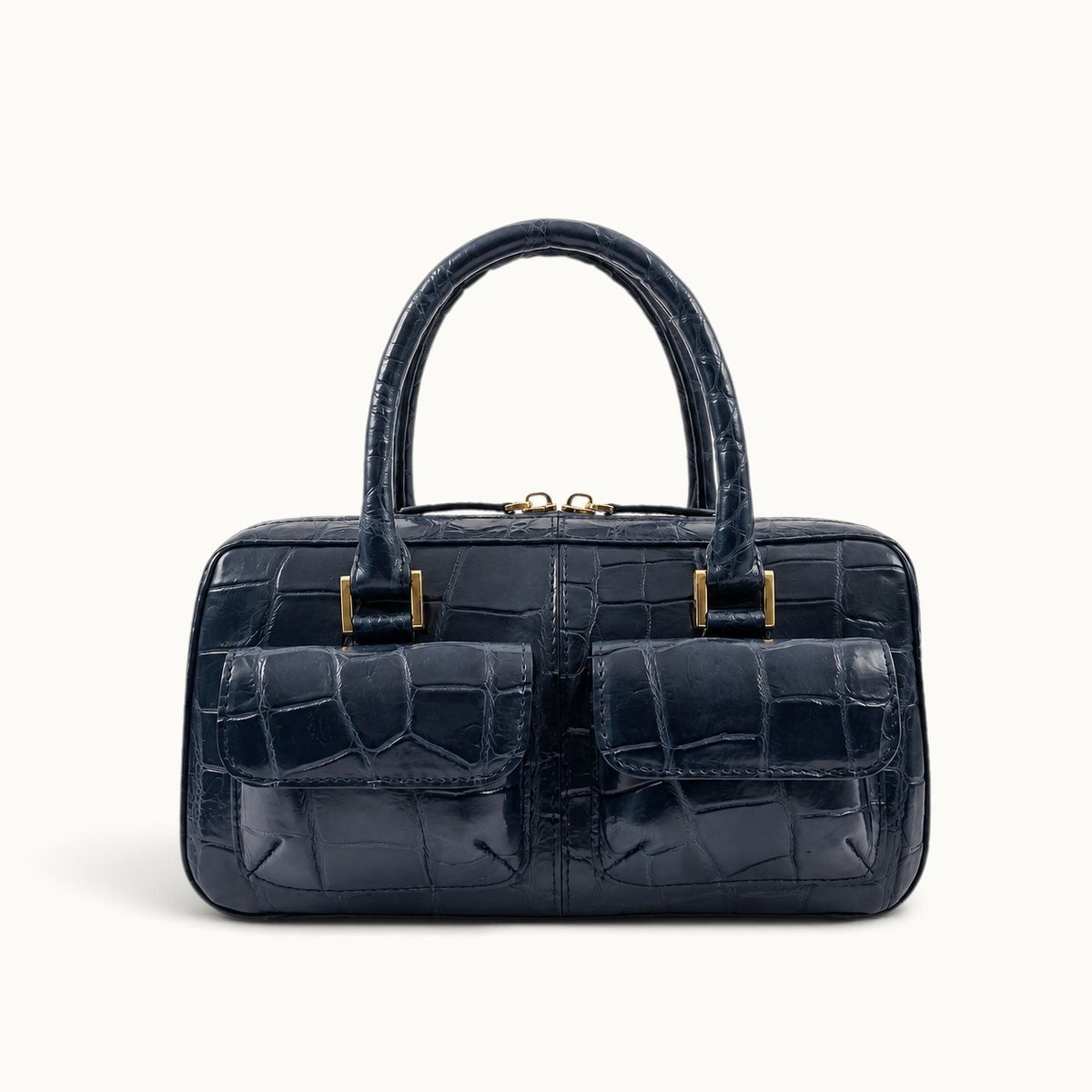The Fairmont Crocodile Handbag in navy blue, front view with double top handles and front flap pockets.