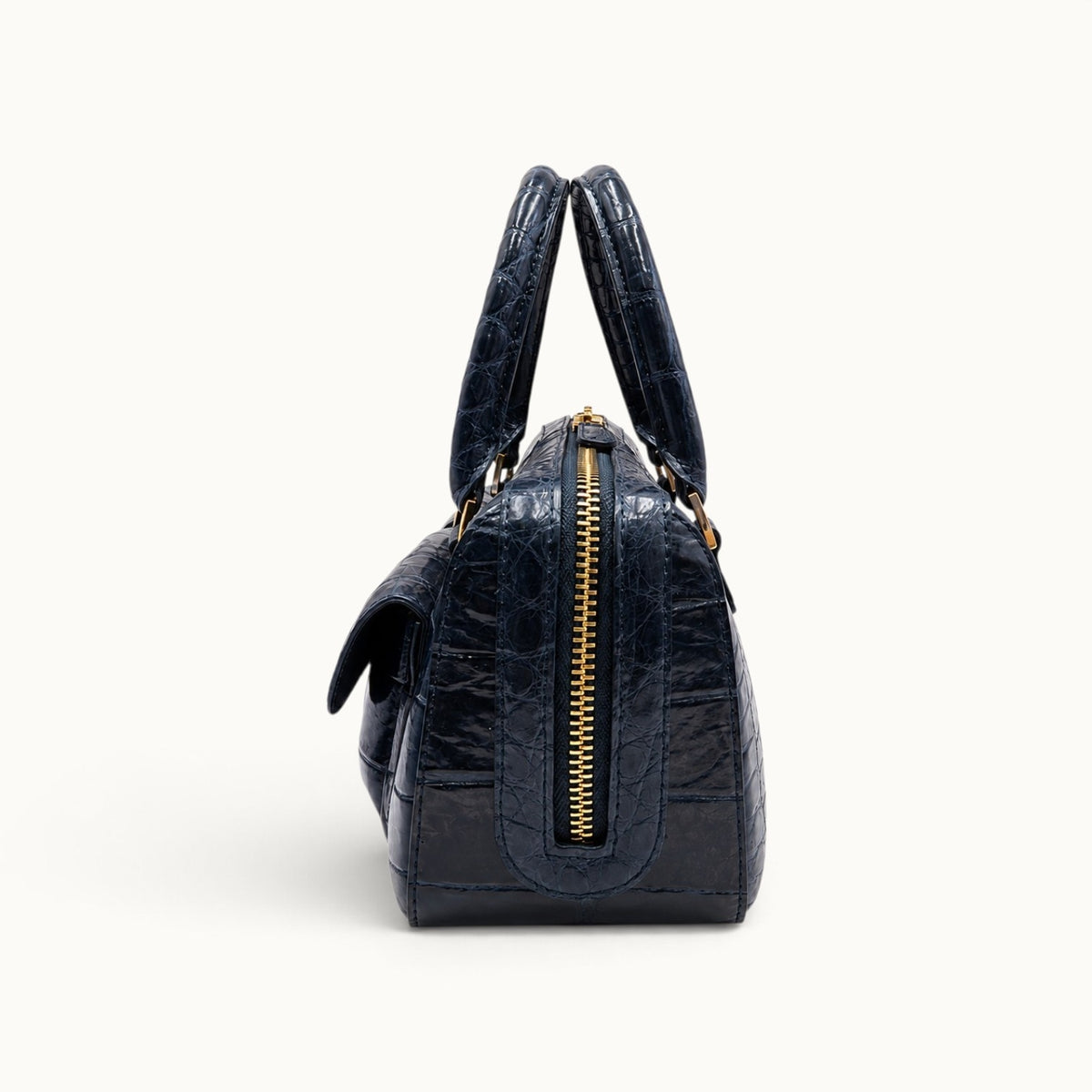 The Fairmont Crocodile Handbag in navy blue, side view displaying the zip-top closure and structured profile.