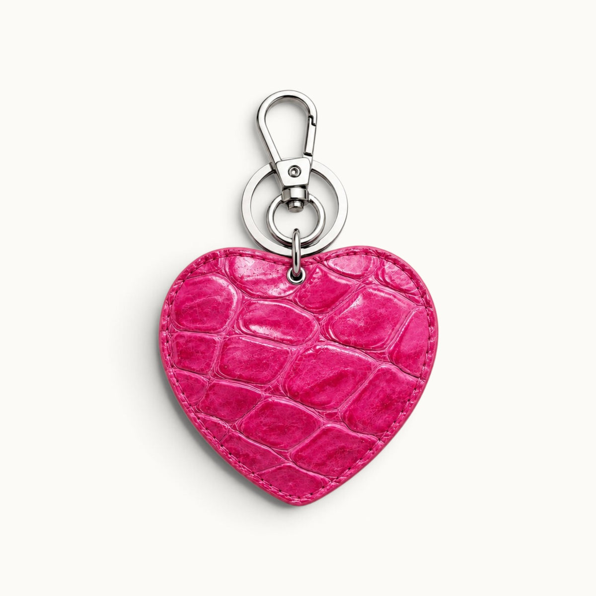 Fuchsia Rose Siamese crocodile heart charm with natural scale texture and polished silver-tone hardware, designed as a luxury handbag and key accessory.