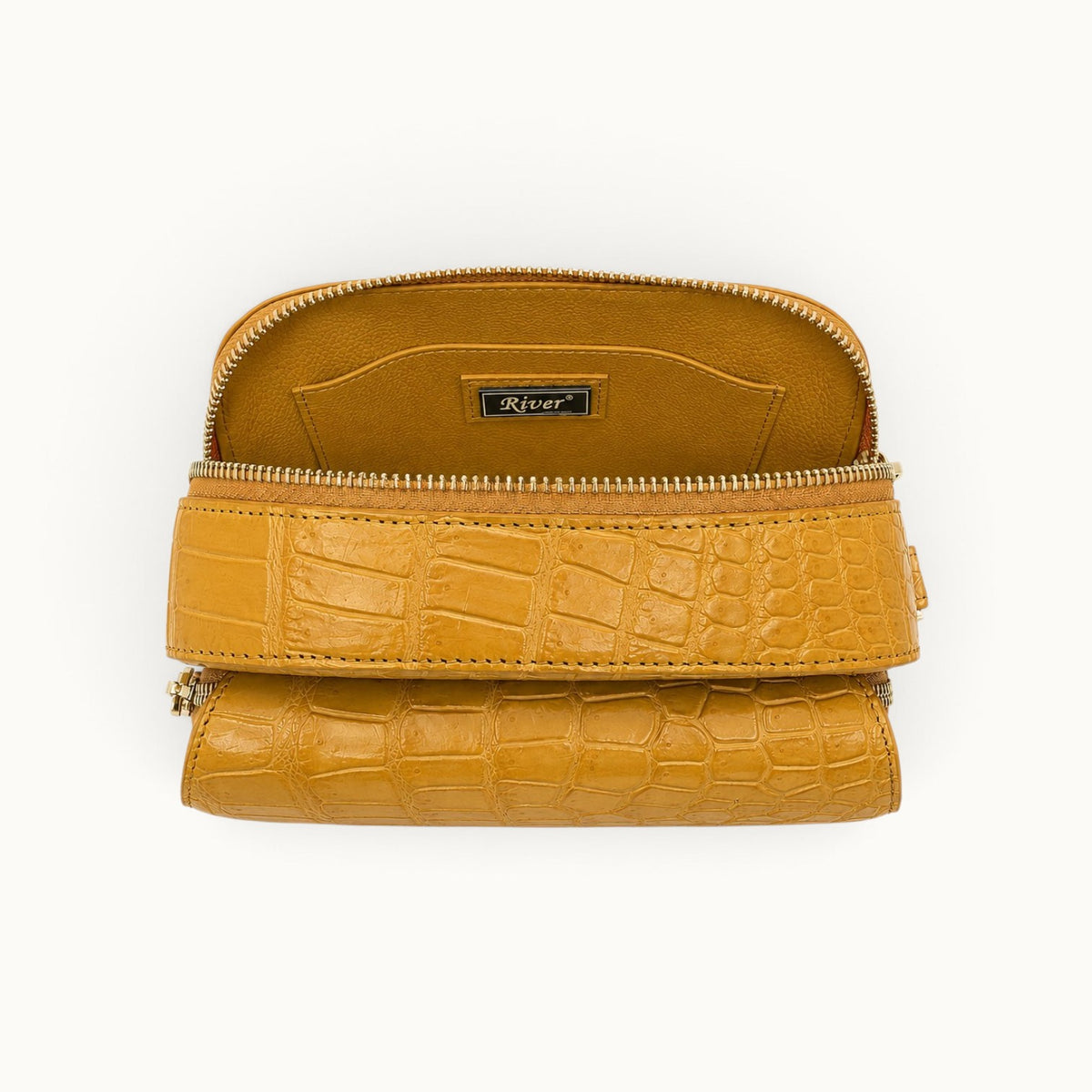 Main compartment of the Grosvenor crocodile crossbody bag with full-grain cow leather interior, slip pocket, and River plaque.