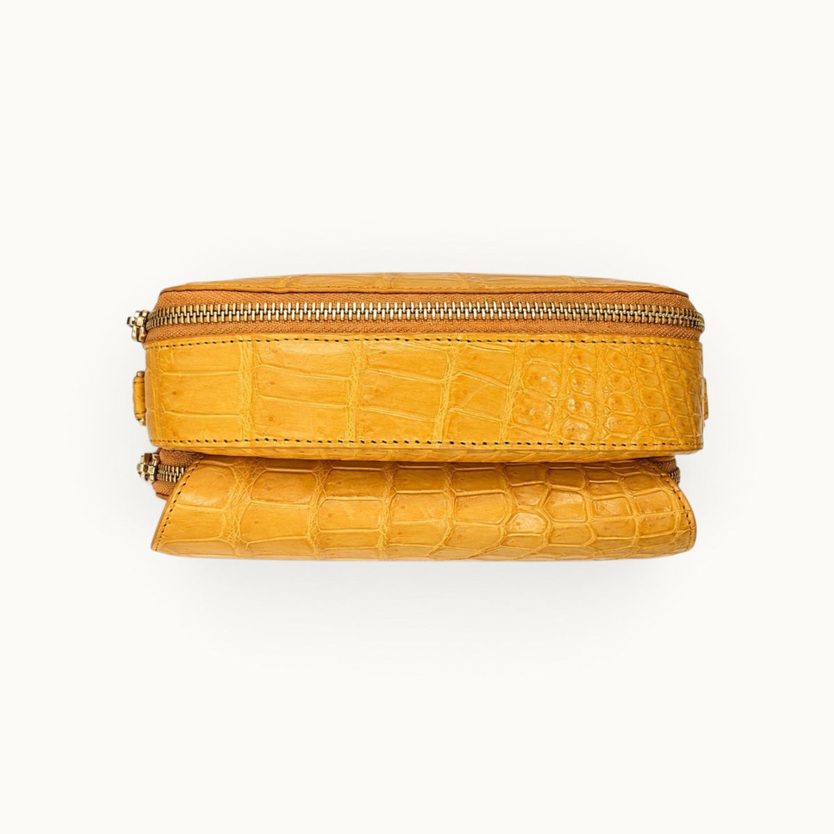 Top construction view of the Grosvenor Siamese crocodile crossbody bag showing the main zipper and front compartment.