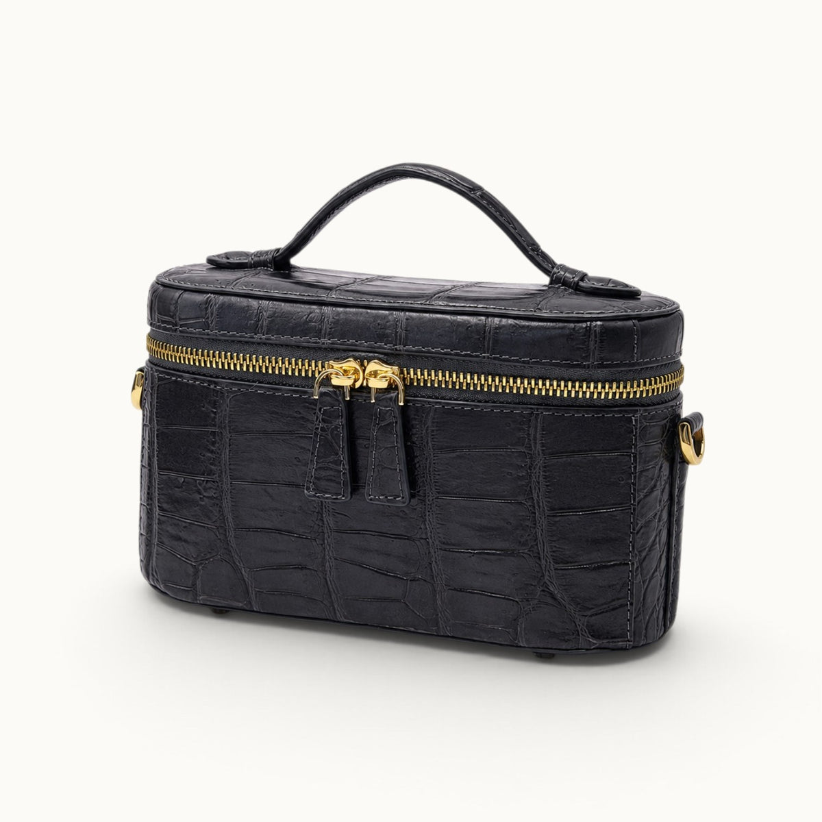 Three-quarter view of a Gunmetal Gray luxury crocodile handbag with structured mini vanity shape and elegant top handle.