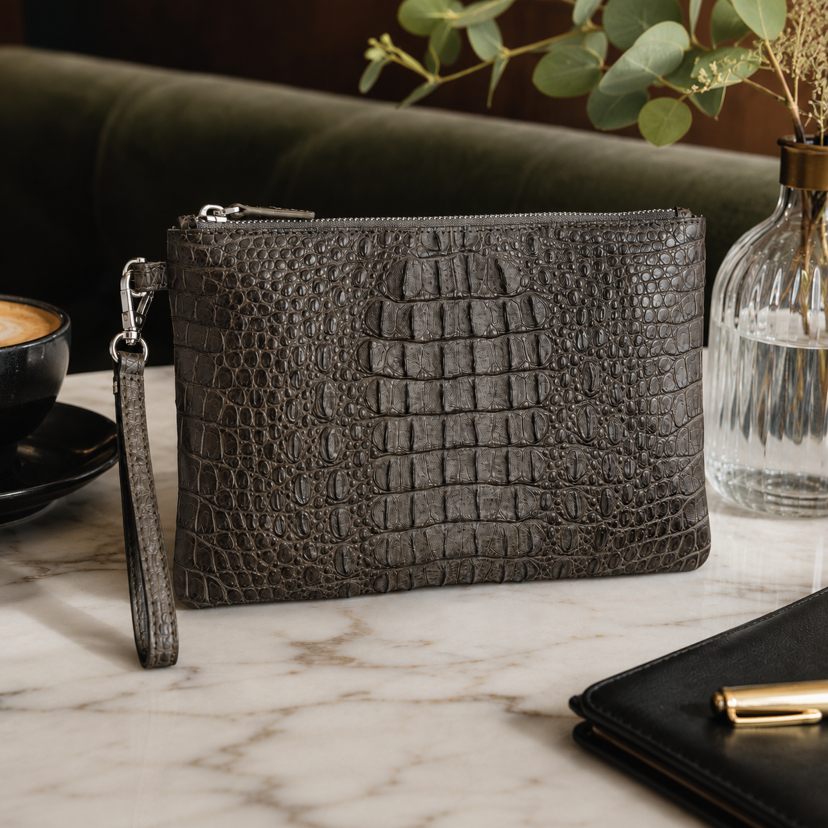 Handcrafted taupe green crocodile clutch presented in an elegant luxury lifestyle setting