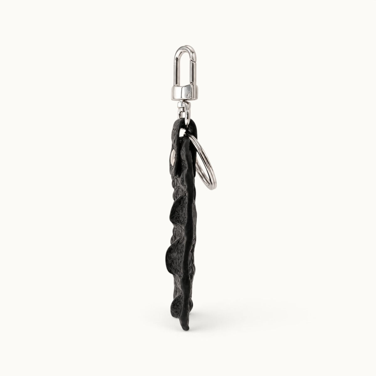 Side profile of the Kensington black genuine alligator leather key fob showing its slim construction, raised scale depth, polished silver-tone clasp, and large key ring.