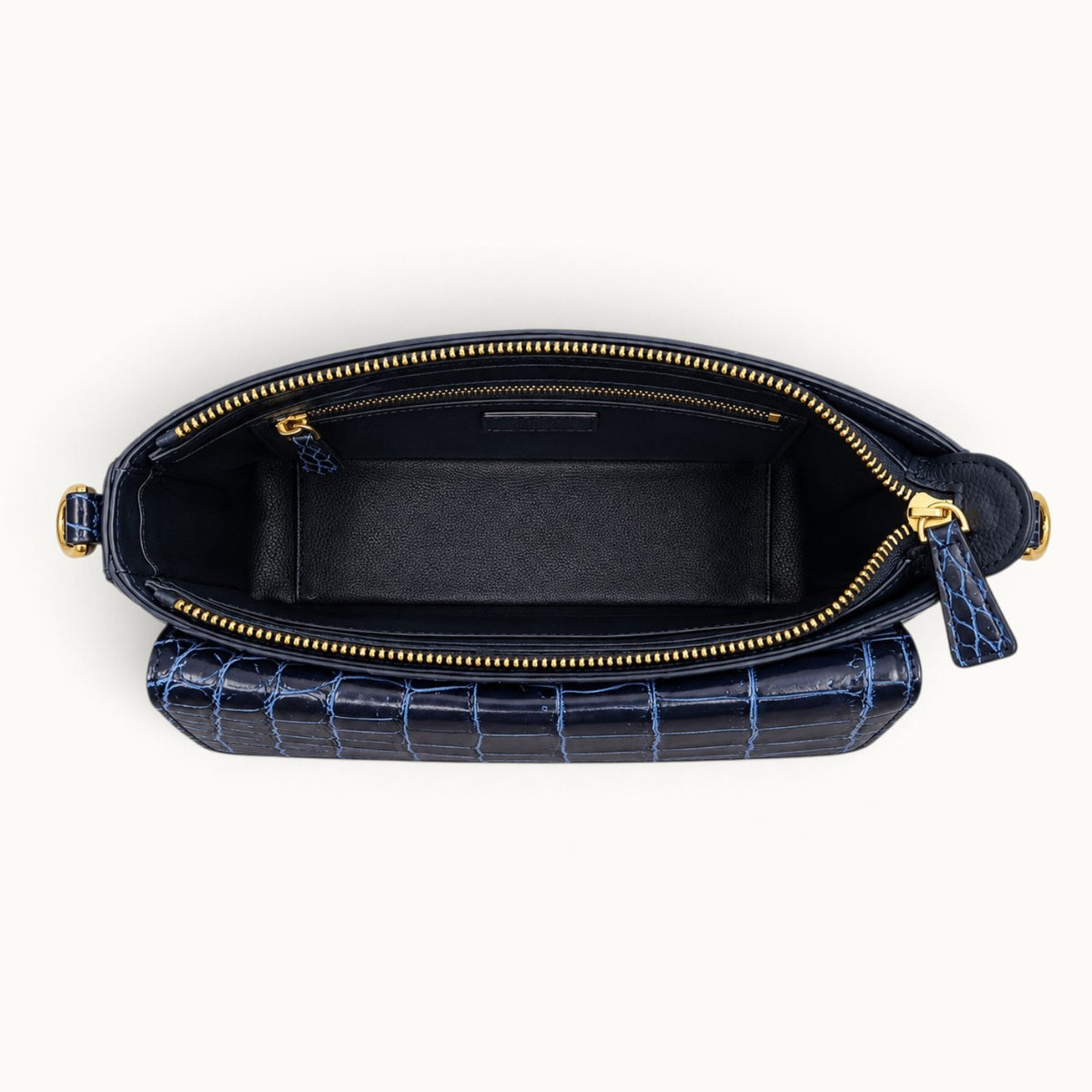 Top-down interior view of navy crocodile bag showing black leather lining, main compartment and zip pocket