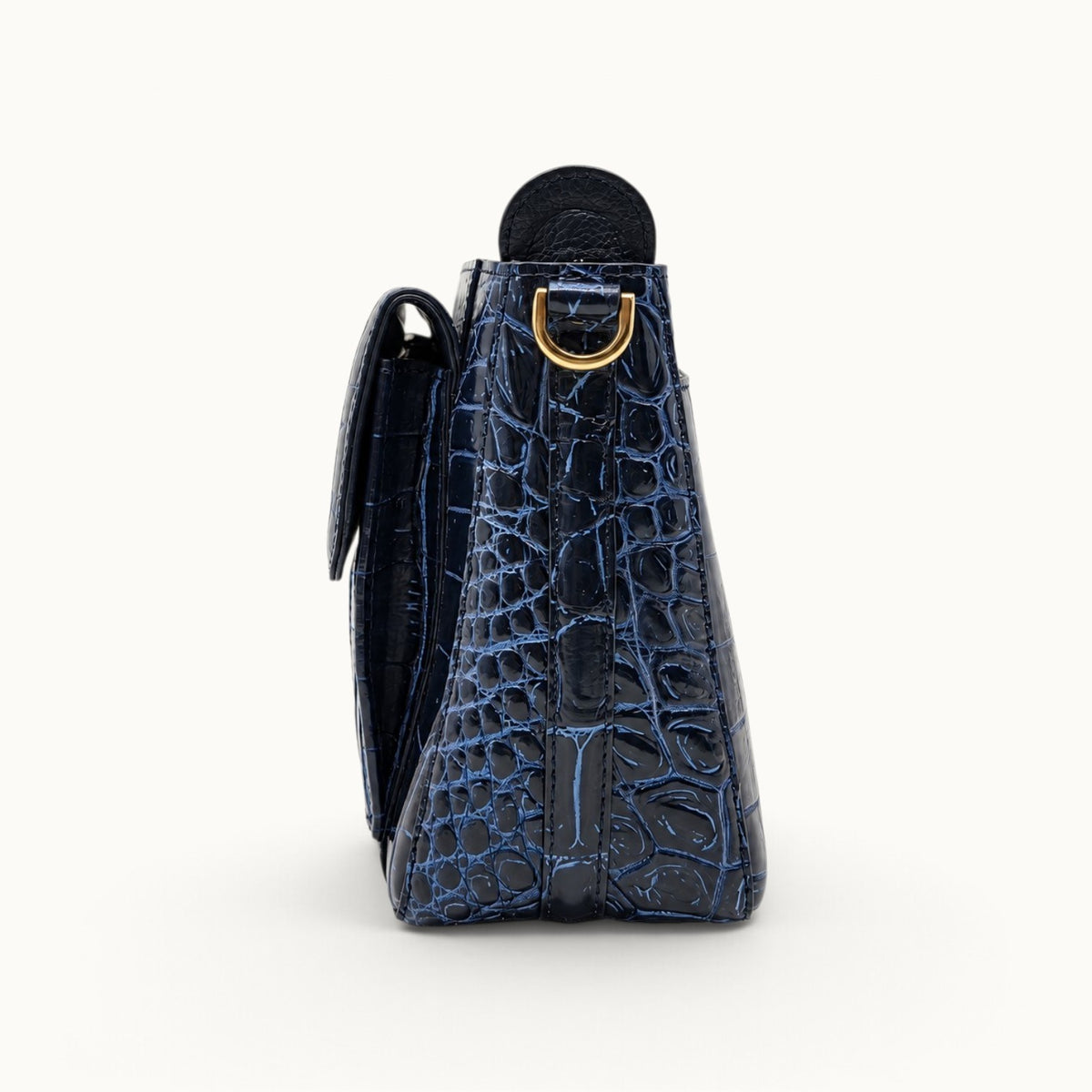 Side profile of navy crocodile bag showing gusset construction, thickness and gold D-ring
