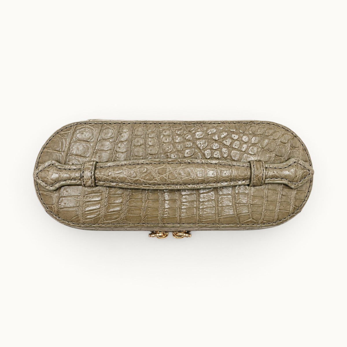 Top view of The Clarendon Sage Olive crocodile vanity bag highlighting the genuine crocodile top handle and scale pattern.
