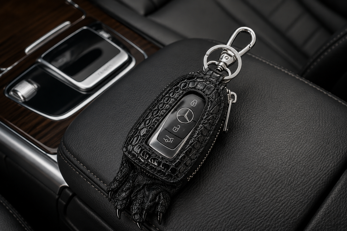 Black Siamensis crocodile leather car key case with Mercedes remote resting on a luxury car’s black leather center console.