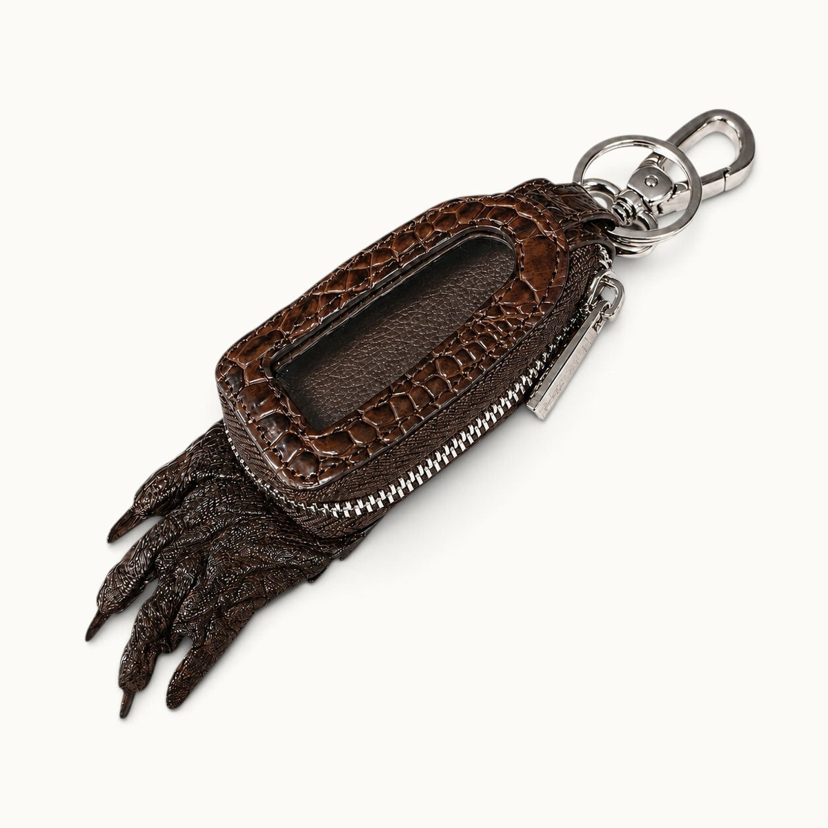Brown Siamensis crocodile leather car key case shown at a three-quarter angle with clear front window, YKK zipper, silver-tone hardware, and sculpted claw detail.
