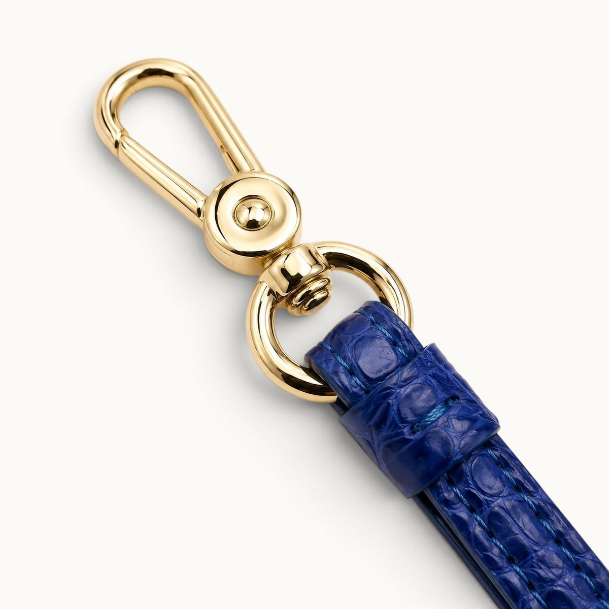Close-up of the Royal Blue Stanhope crocodile wrist strap with polished gold-tone swivel clasp and ring hardware.