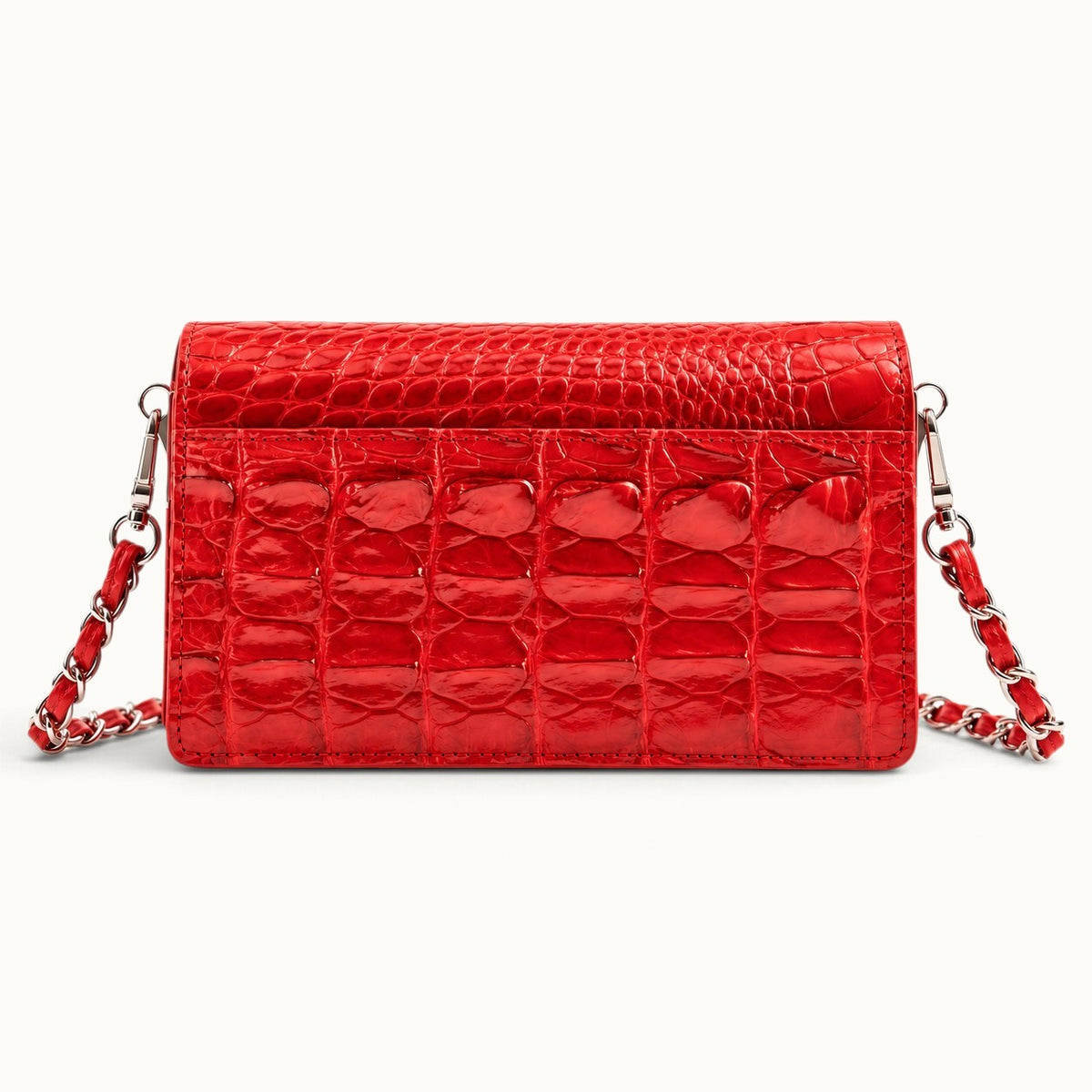 Back view of The Chelsea red Siamese crocodile leather shoulder bag featuring its natural scale pattern and exterior slip pocket.