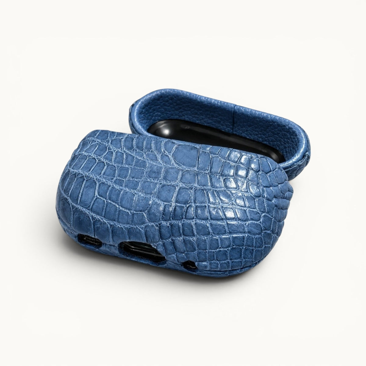 Open bottom angle view of The Crocodile AirPods Case in French Blue featuring genuine Siamese crocodile leather and precise charging port cutouts.