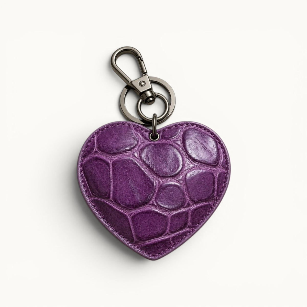 The Heart Key Charm in rich purple Siamese crocodile leather with bold natural scales, stitched edges, and polished silver-tone hardware.