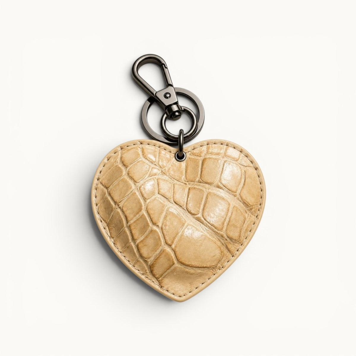 The Heart Key Charm in sand Siamese crocodile leather with natural scale texture, stitched edges, and polished silver-tone hardware.