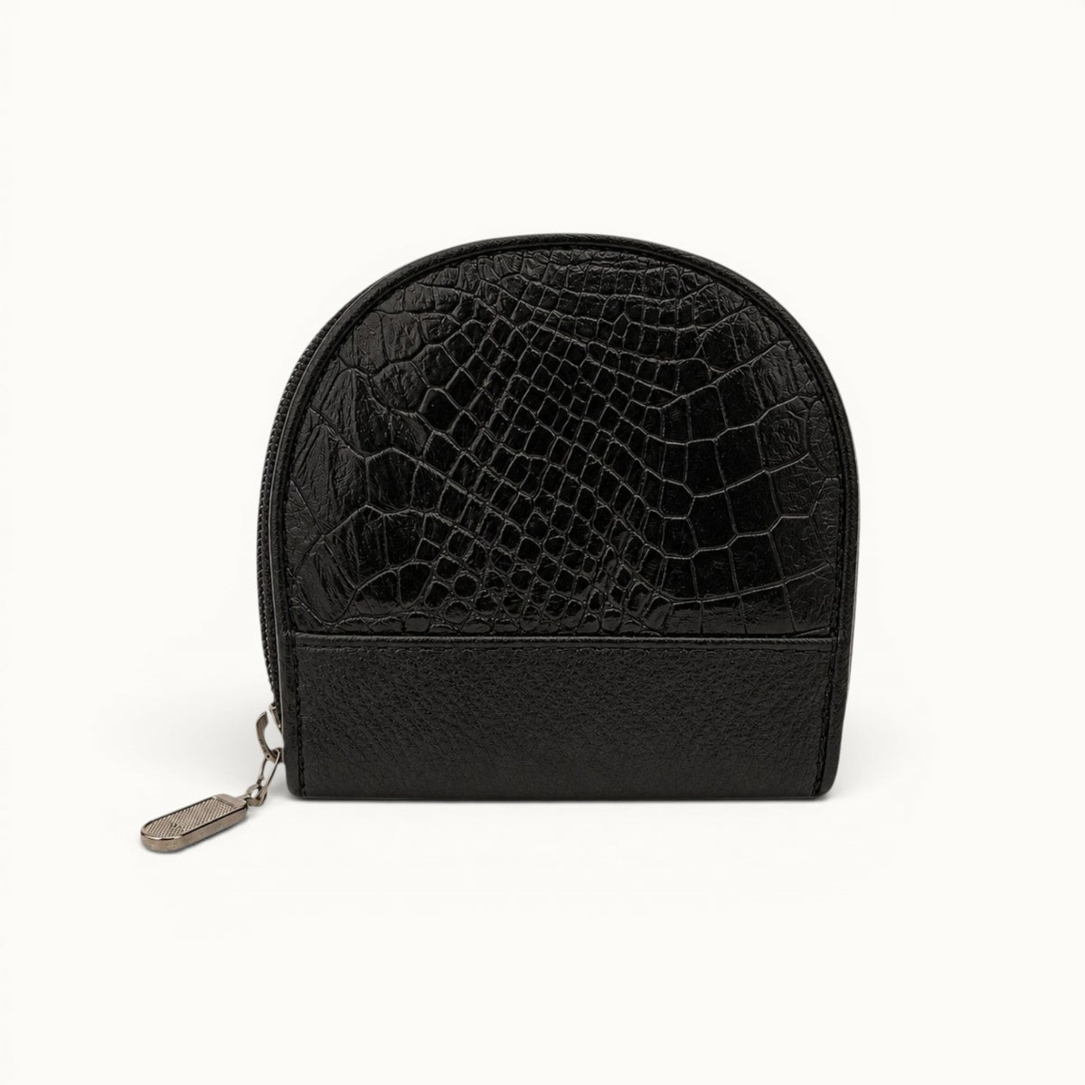 The Sovereign black crocodile leather change purse with natural exotic scales, a structured rounded shape, and a silver-tone zipper pull.