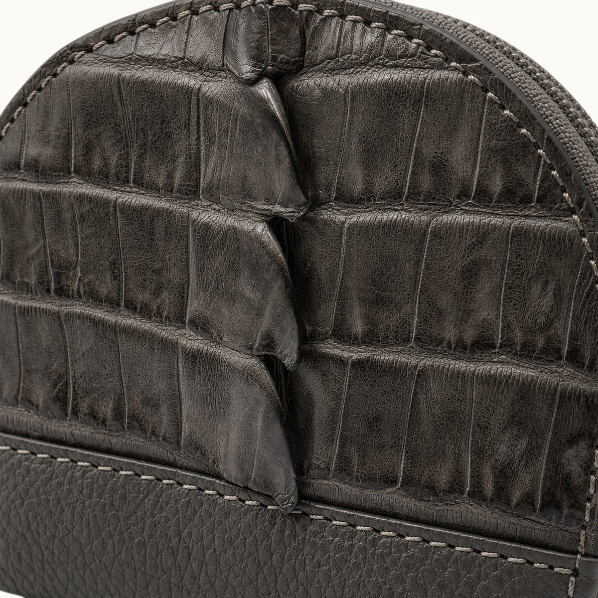 Close-up of The Sovereign taupe green crocodile leather coin pouch highlighting the natural rectangular scales, fine grain, precise stitching, and pebbled leather trim.