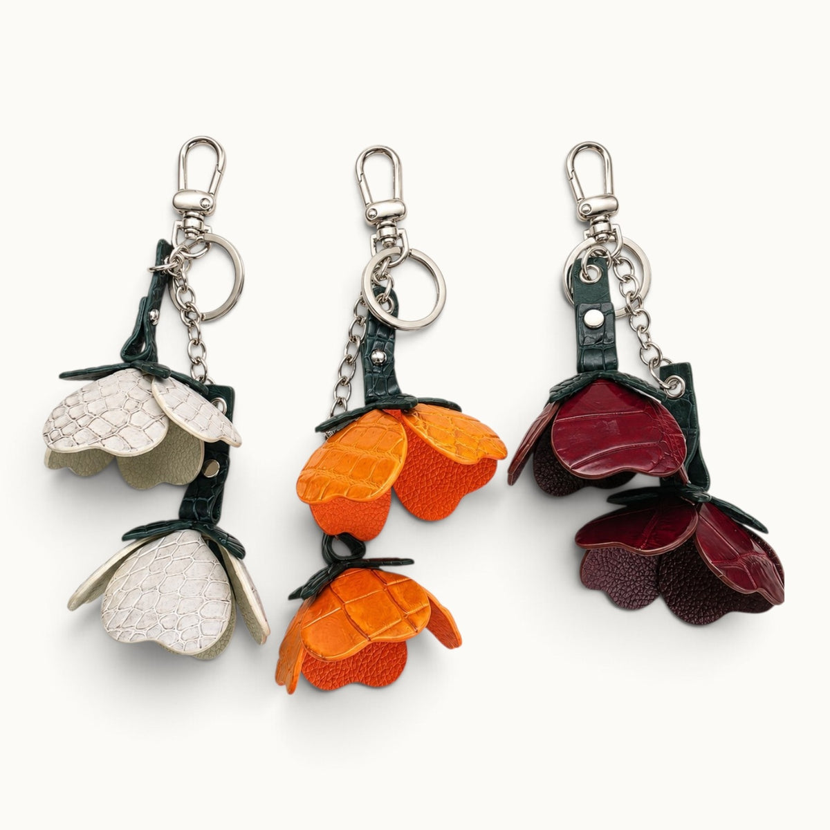 Valencia crocodile flower charm collection shown in Stone Ivory, Burnt Orange, and Bordeaux Red