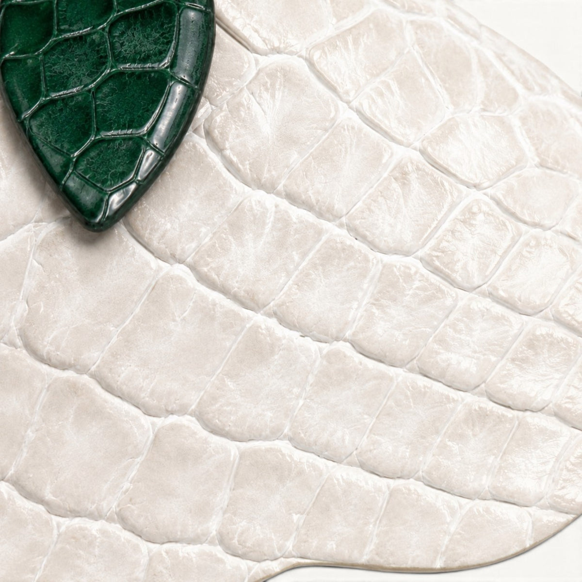 Close-up of Pearl White crocodile leather scales with a dark green crocodile leather leaf on The Valencia flower charm