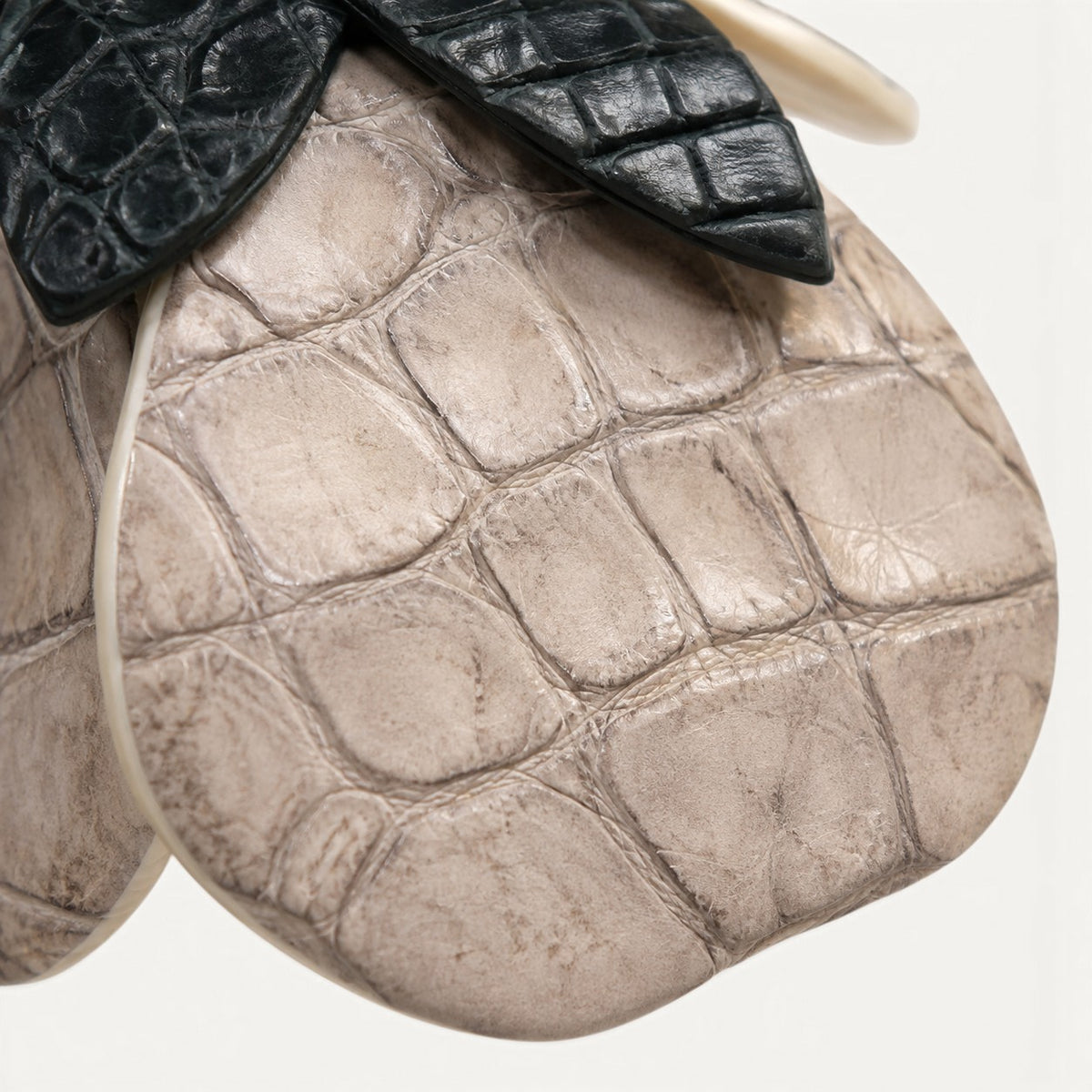 Close-up of Stone Ivory crocodile leather scales with dark green crocodile leather leaves on The Valencia flower charm